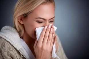 64540825 – cold woman holding handkerchieif blowing nose
