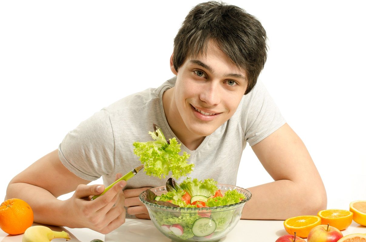 Man having a table full of organic food,juices and smoothie. Che
