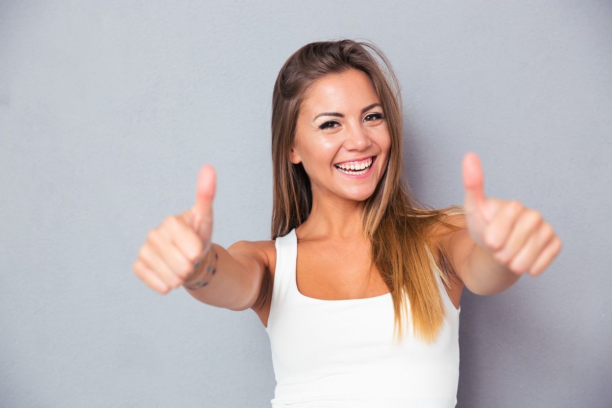 Cheerful lovely girl showing thumbs up