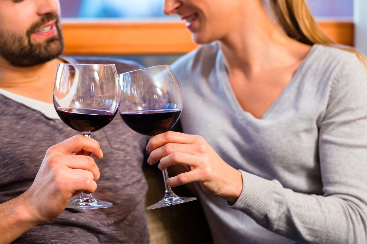 Young handsome couple drinking red wine at home