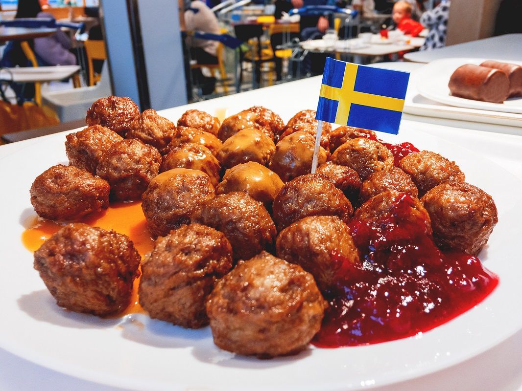 Fresh tasty meatballs with cranberry sauce on white plate with S