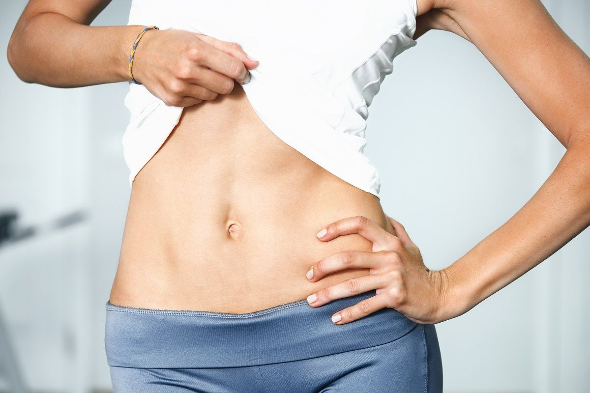 Closeup of young slim woman with six-pack torso.