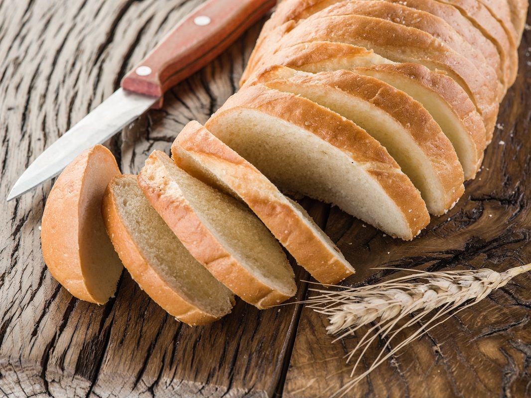 Sliced white bread on the wooden plank.