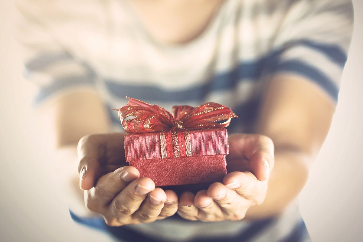 Young man giving and presenting a gift to someone.