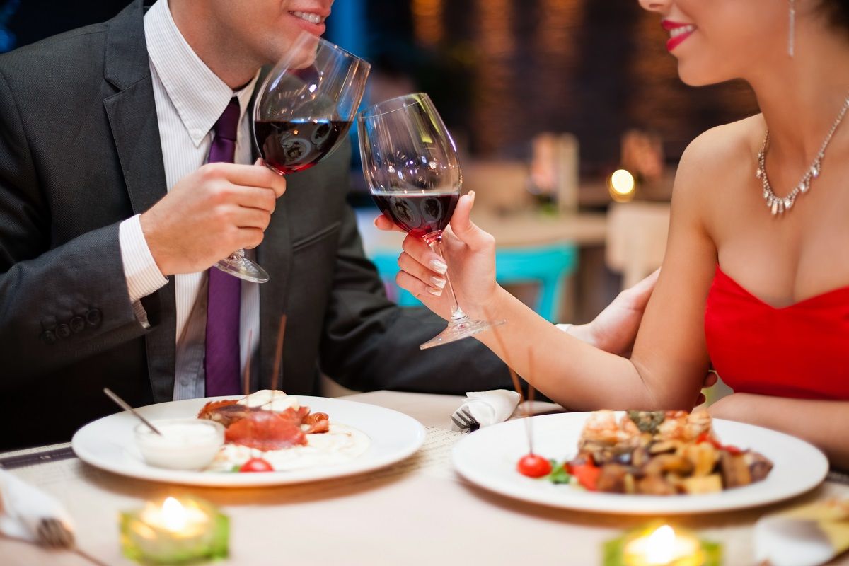 21260070 – hand holding a glass with red wine and toasting, celebration