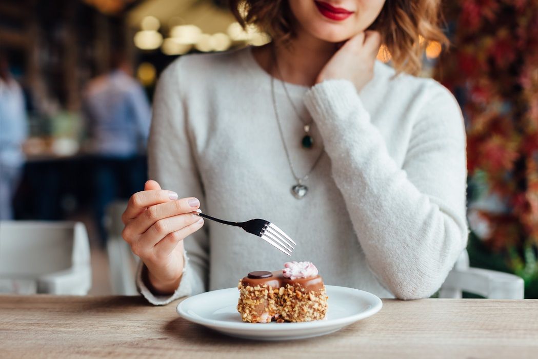 Woman eating cake in  cafe