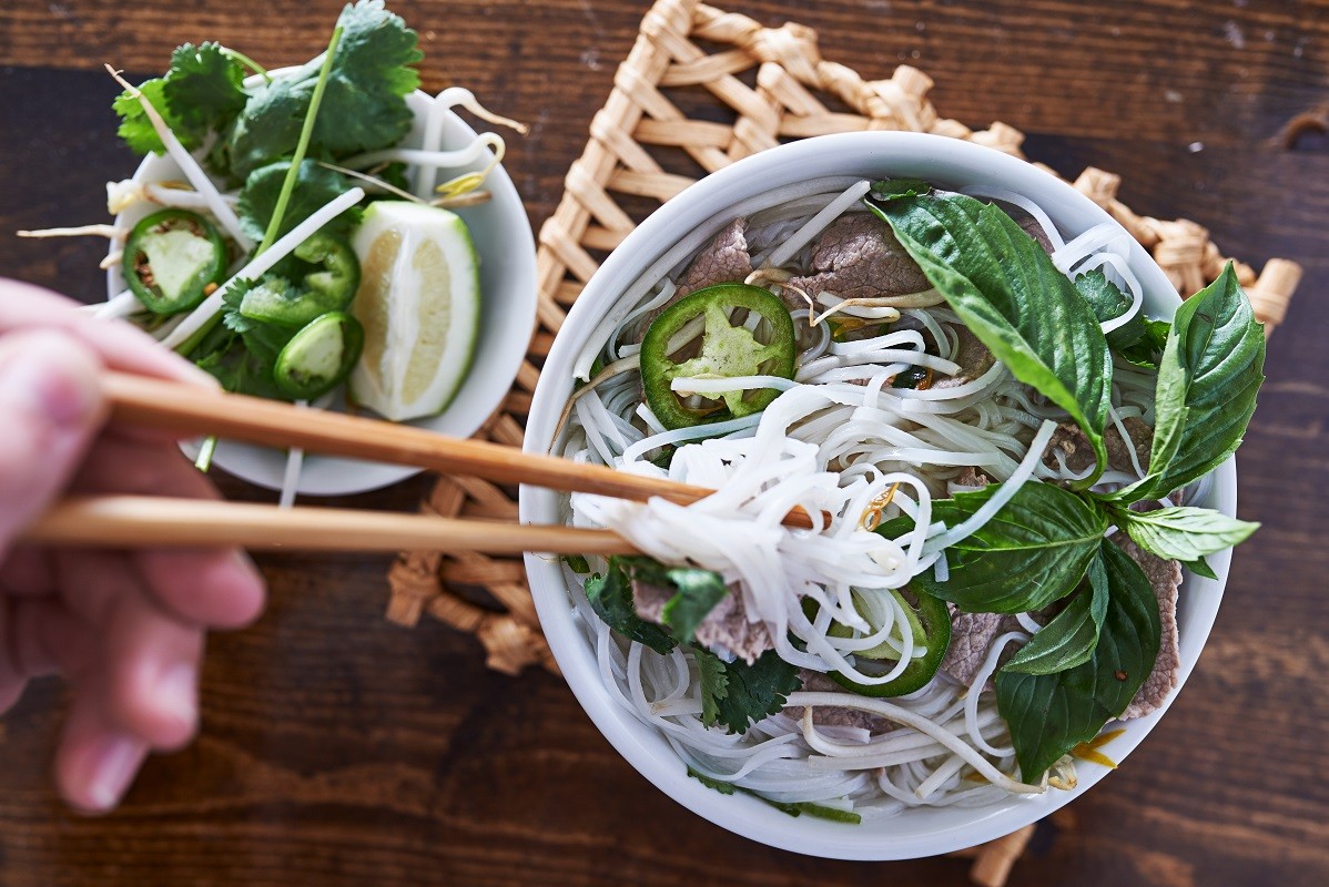 eating a bowl of pho with chopsticks