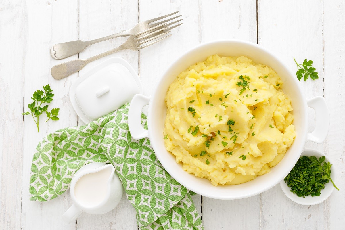 Mashed potato with butter and milk on table