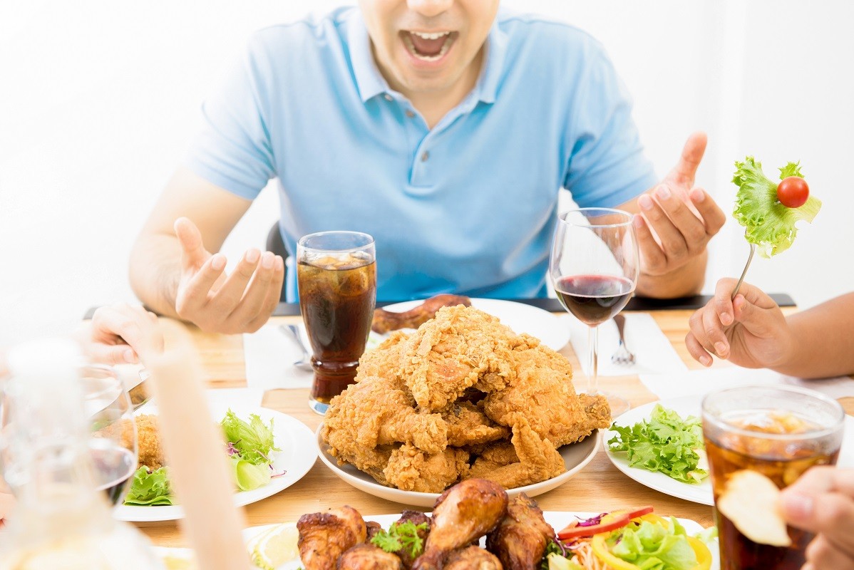 Food and drinks on dining table in front of young man
