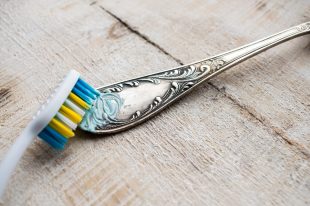 Cleaning the cutlery with a brush and paste. Cleaning Darkened s