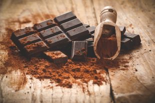 Noble dark chocolate on a wooden table in vintage style.