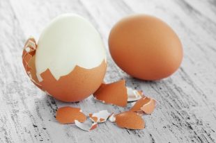 Peeled boiled egg on wooden background