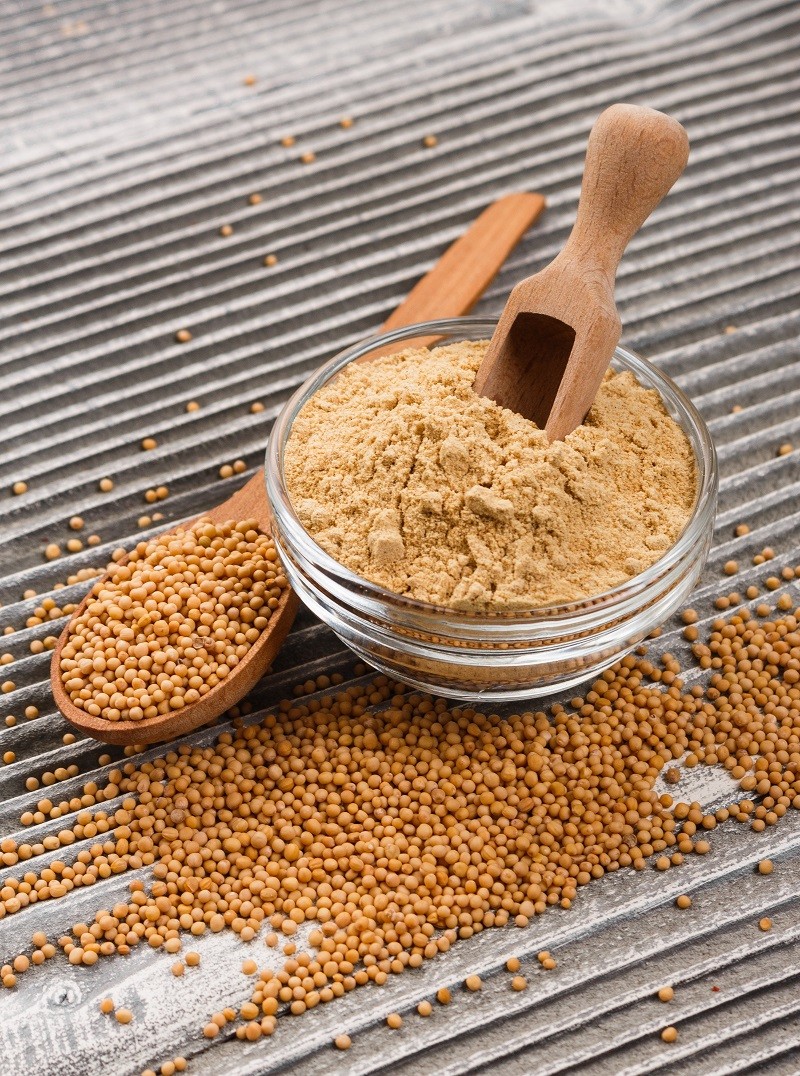 mustard in a bowl on a rustic background