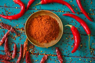 Chilli powder and fresh peppers on table