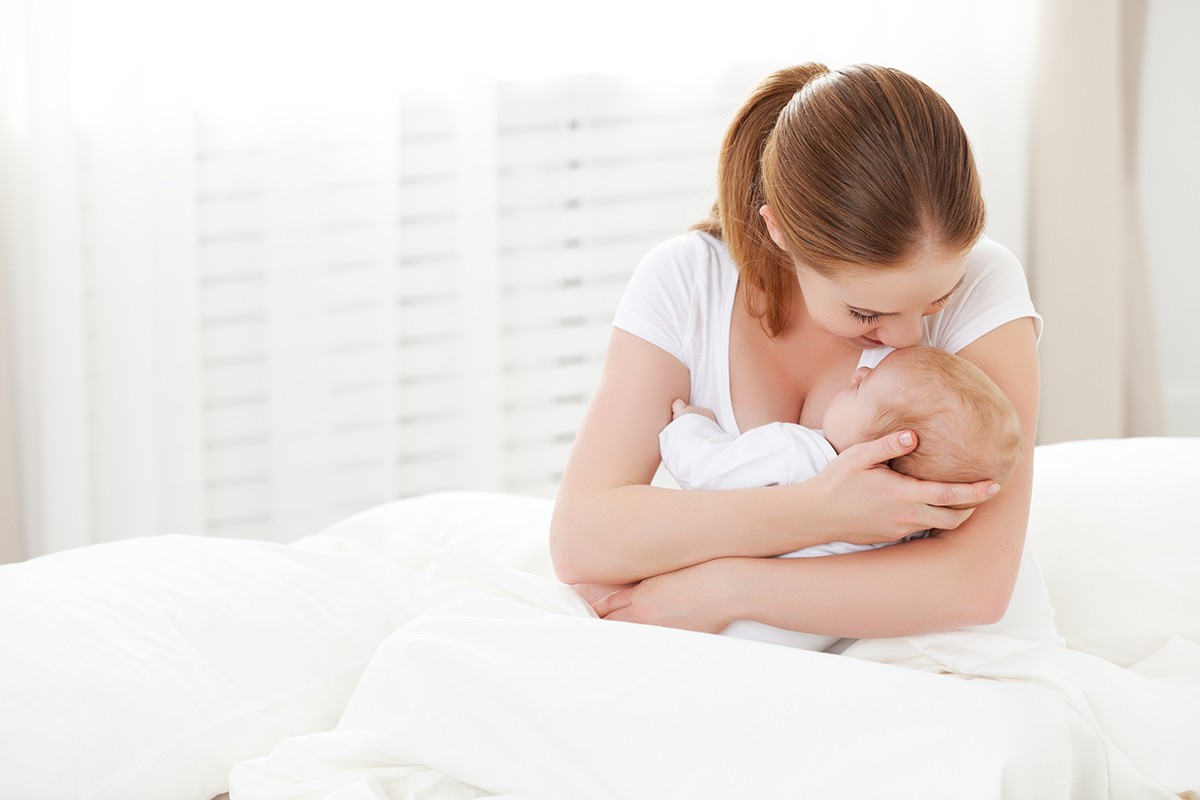 happy family newborn baby in  embrace mother in white
