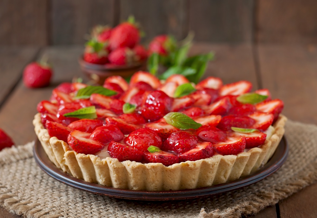 Tart with strawberries and whipped cream decorated with mint leaves