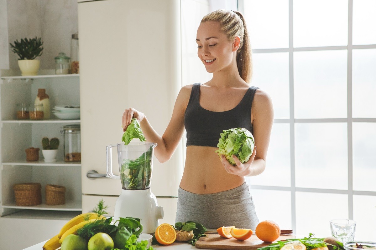 Young woman making detox smoothie at home