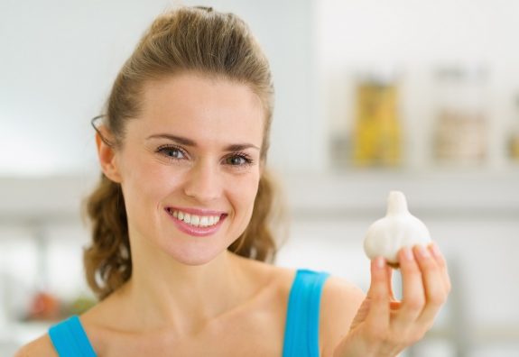 18347521 – smiling young housewife showing garlic