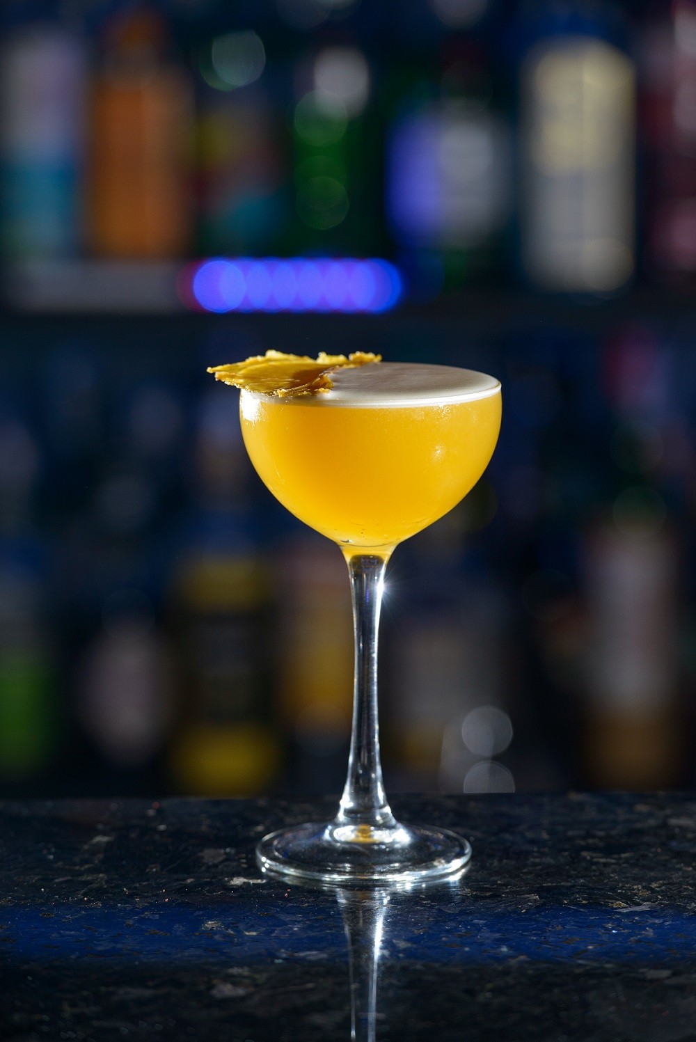 yellow refreshing coctail on a bar desk