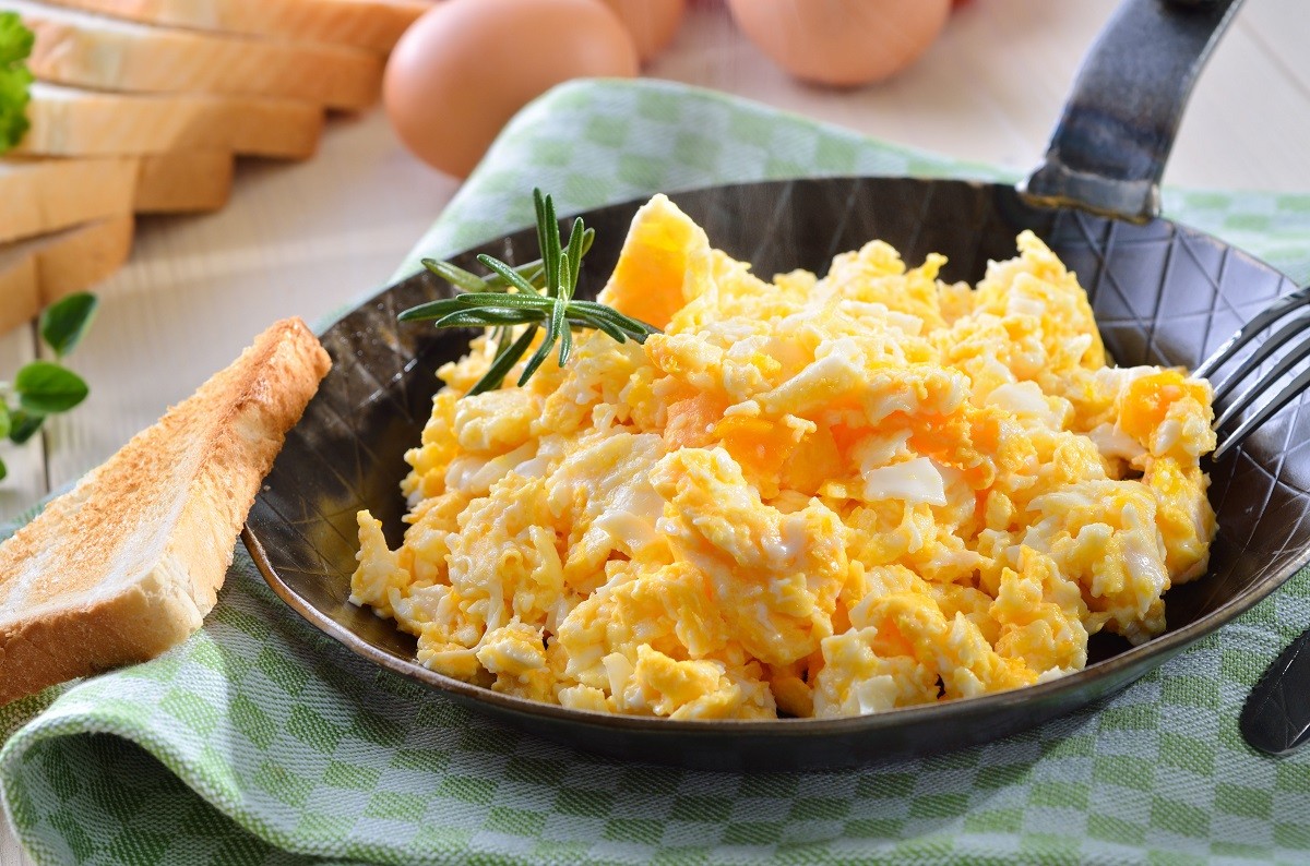 Scrambled eggs served in a pan with toast