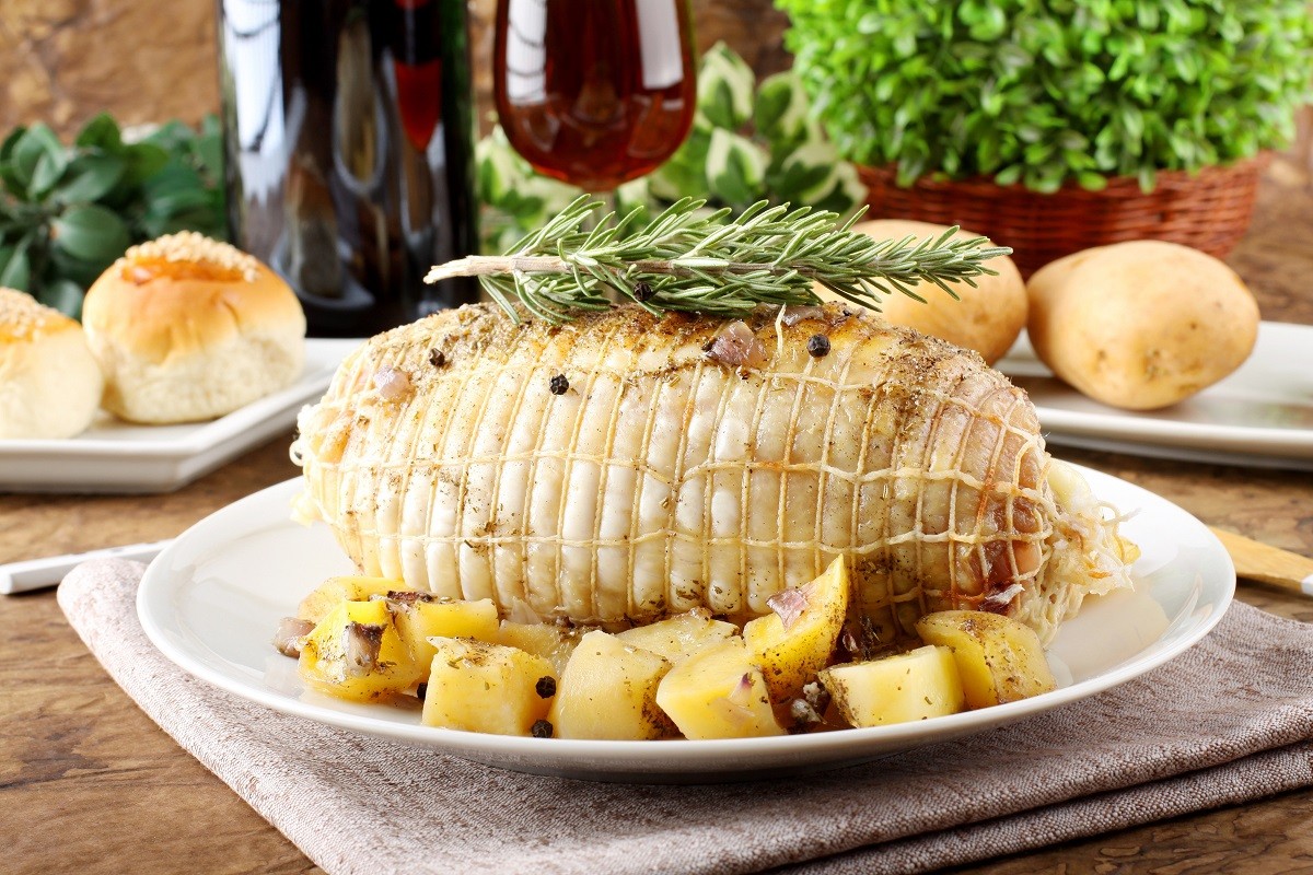 Chicken roll stuffed  with baked potatoes on complex background