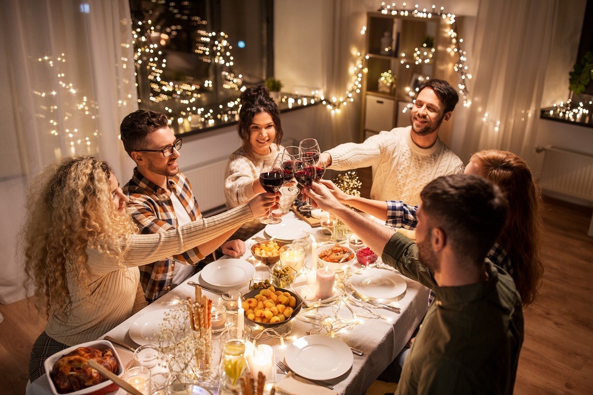 happy friends drinking red wine at christmas party