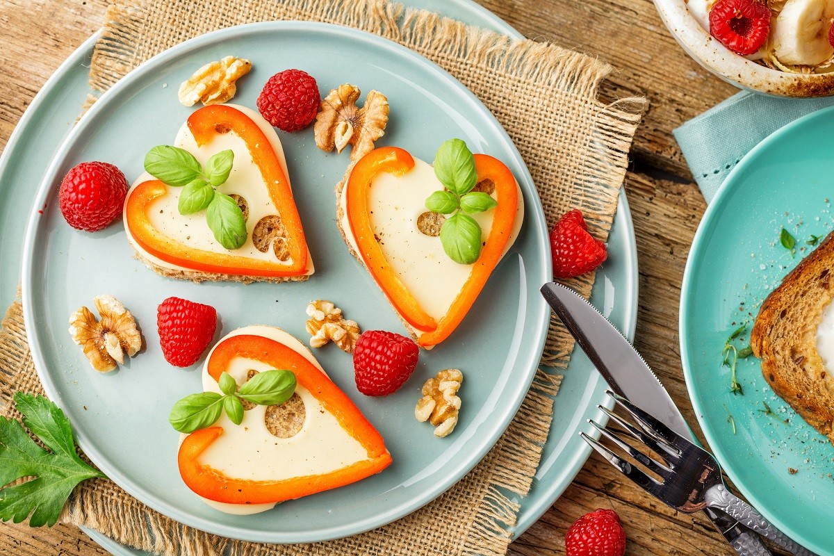 Breakfast on Valentine’s Day – fried eggs and bread in the shape of a heart and fresh vegetables.