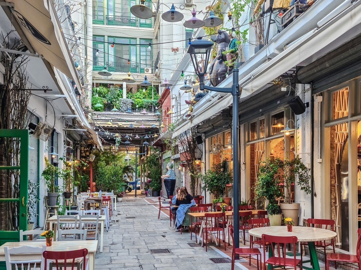 Thessaloniki, Greece – October 14 2019: Hellenic dining scene of people at outdoors tavern restaurants. Less crowd eating & drinking at mostly empty tavernas in the center at Bezesteni area.