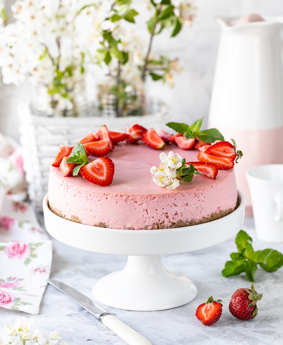 Cheesecake with fresh strawberries on a white table. Selective focus