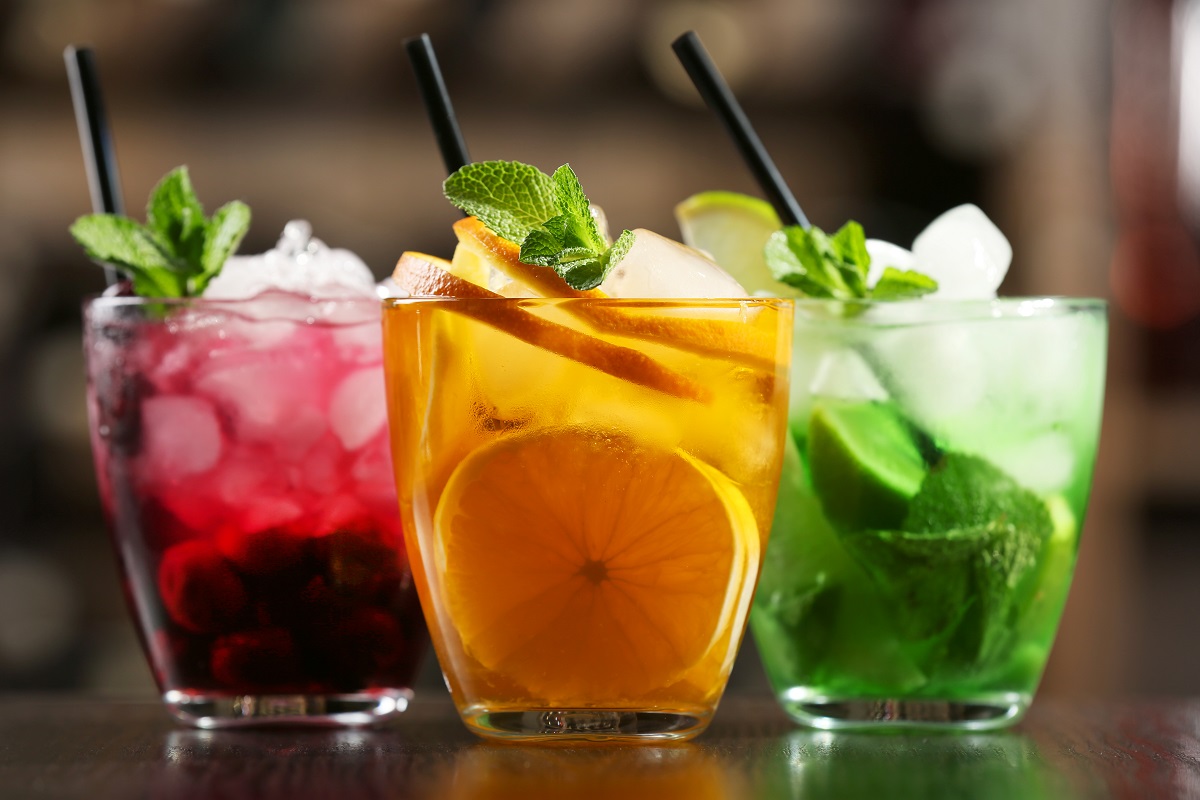 Glasses of cocktails on bar background