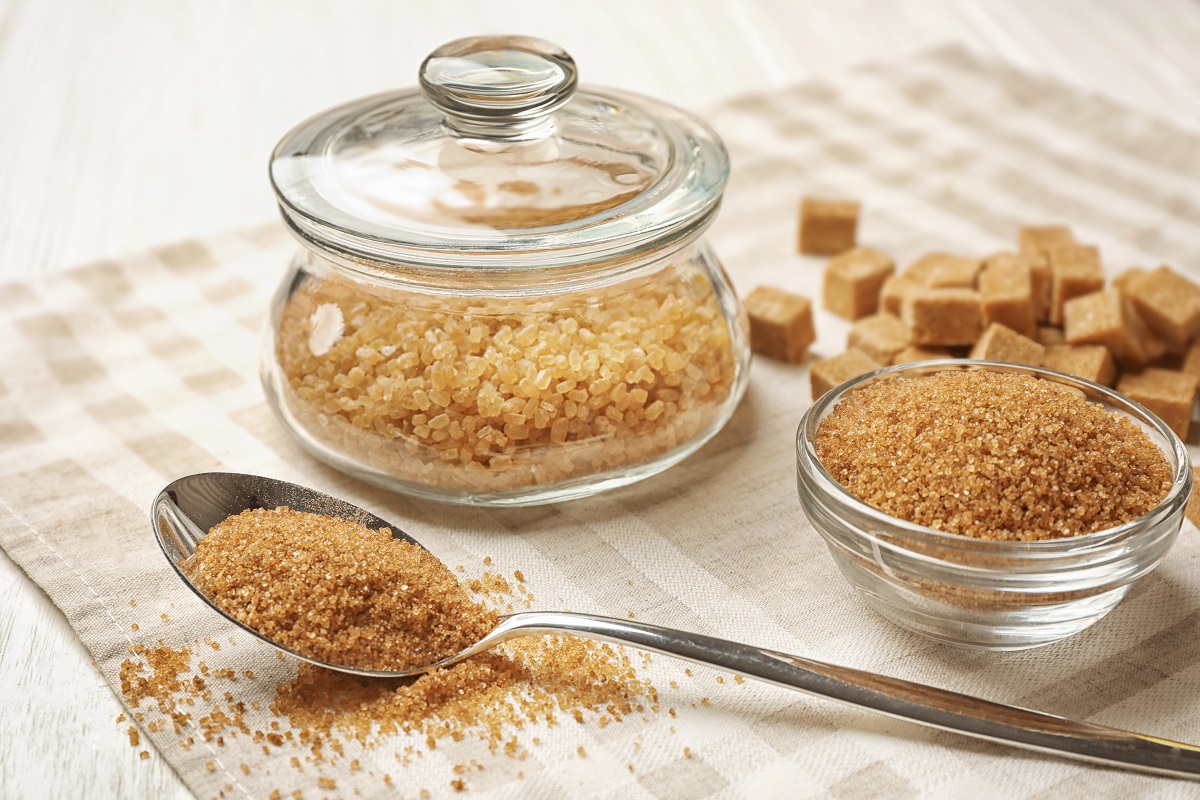 Brown sugar in spoon and dishware on napkin