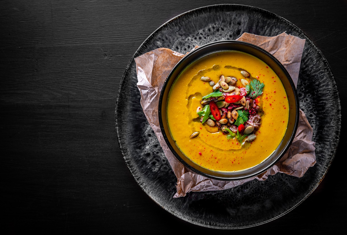 Pumpkin,Soup,In,Black,Plate,On,Black,Wooden,Table,Background