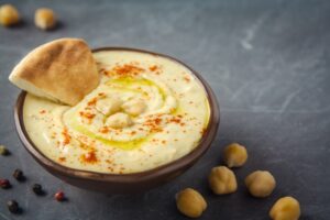 Hummus,In,A,Bowl,And,Pita,Bread,On,Grey,Background.