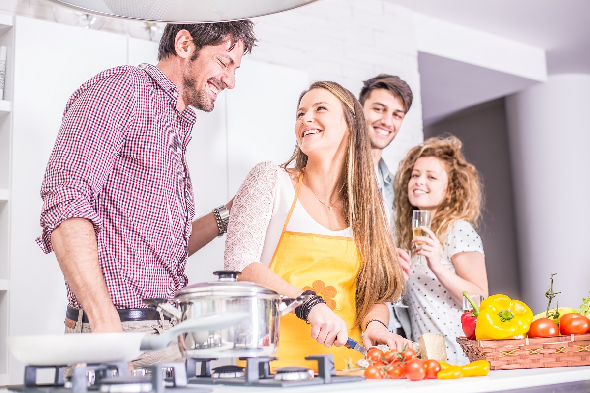 Woman,Cooking,At,Home,And,Laughing,With,Her,Friends,-