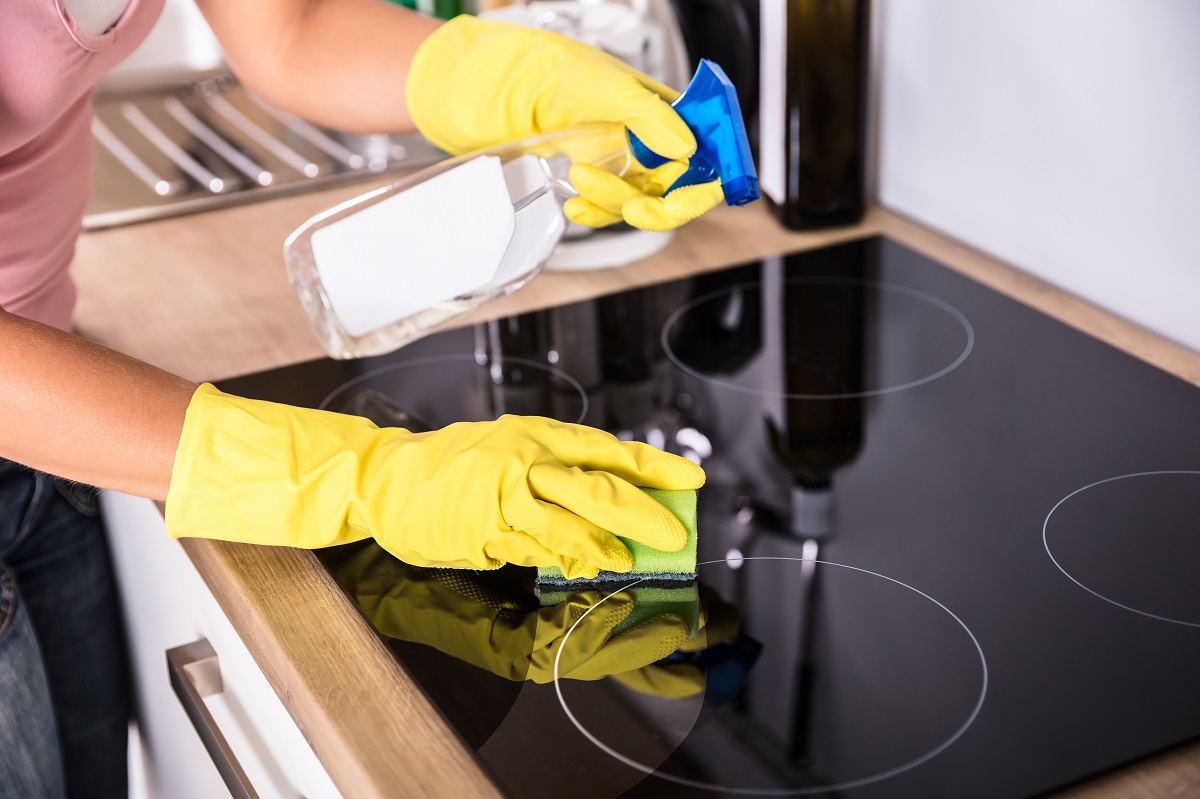 Close-up,Of,Person,Hands,Cleaning,Induction,Stove,In,Kitchen,With