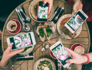 Group,Of,Food,Bloggers,Taking,Photo,Of,Dishes,In,The