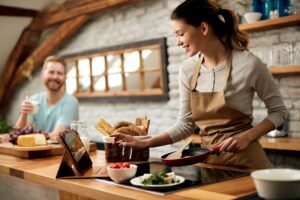 Happy,Woman,Preparing,Food,While,Following,Recipe,On,Digital,Tablet