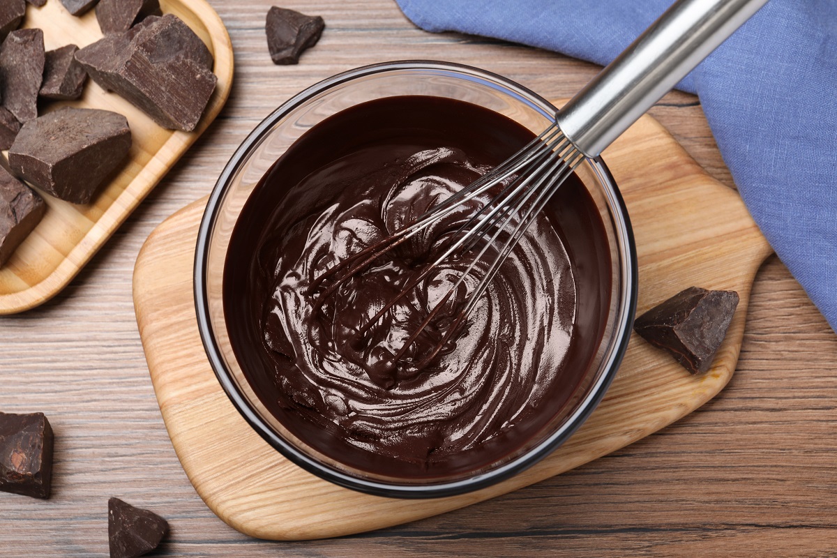Delicious,Chocolate,Cream,And,Whisk,In,Glass,Bowl,On,Wooden