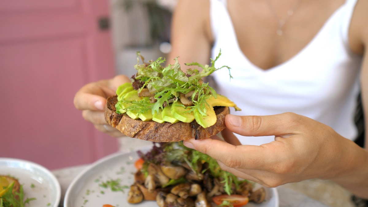 Young,Caucasian,Woman,Eating,Healthy,Vegan,Avocado,Toast,With,Great