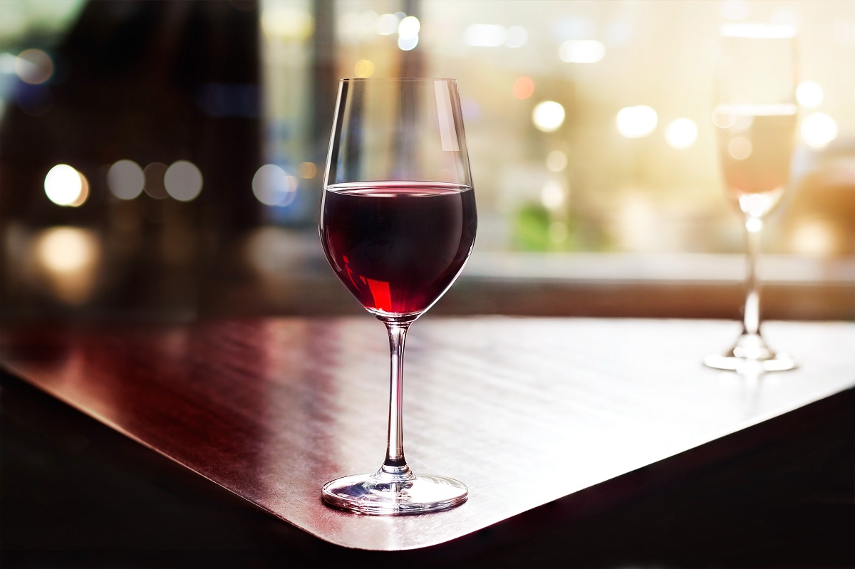 Wine,Glass,In,Entertaining,Room,Among,Sunset,Window,Background