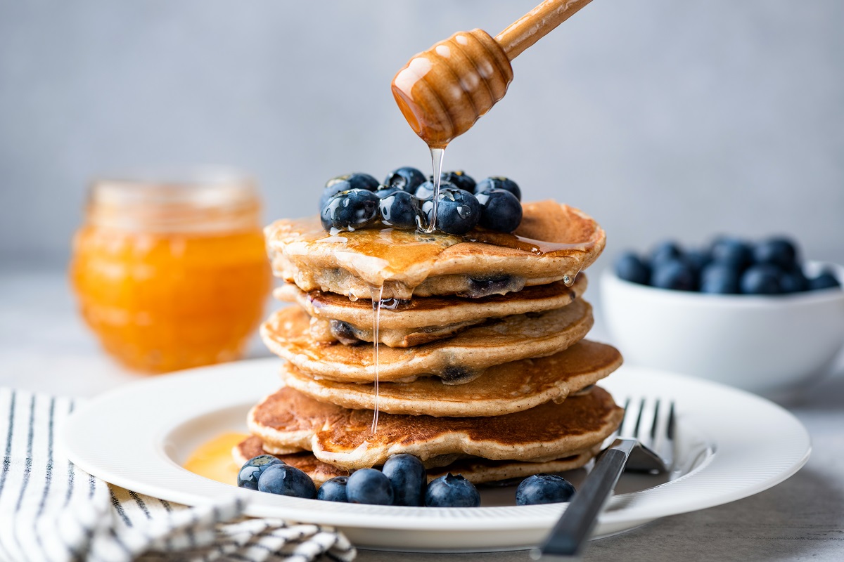 Pouring,Honey,On,Stack,Of,Pancakes.,Homemade,Oat,Pancakes,With