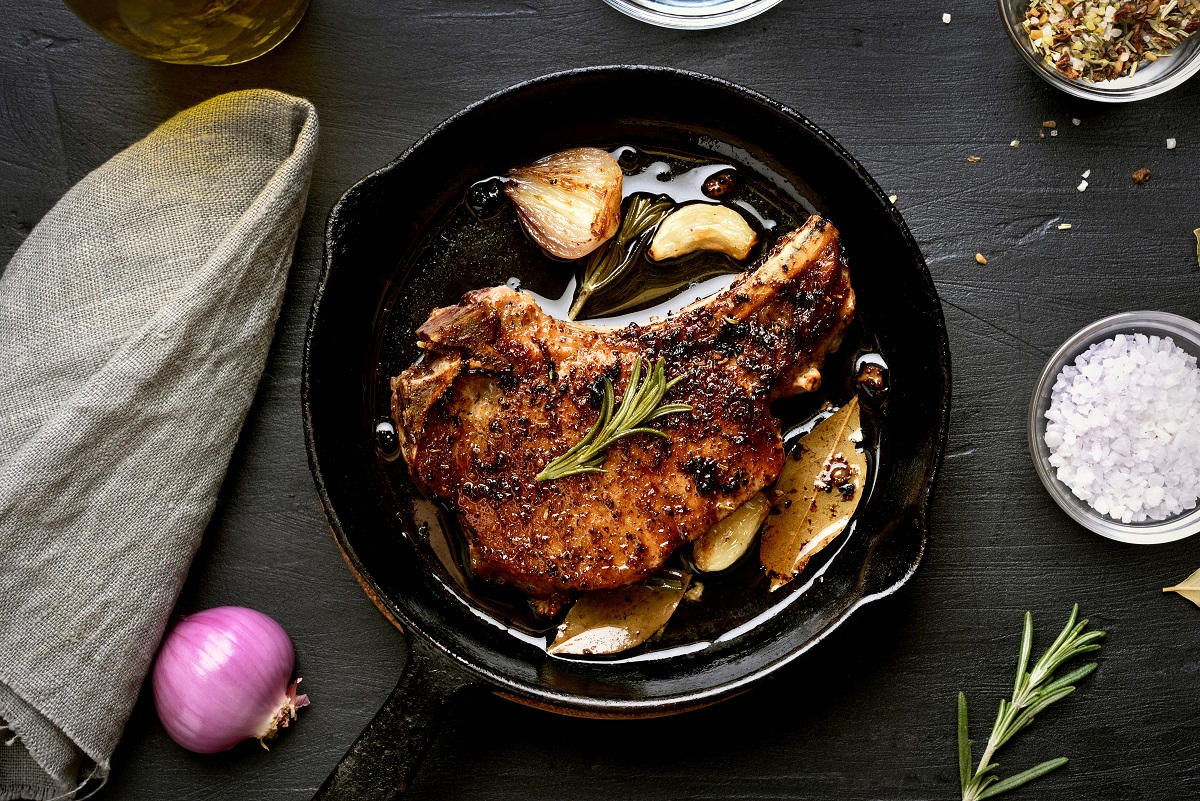 Roasted,Pork,Steak,In,Frying,Pan,Over,Dark,Background,,Top