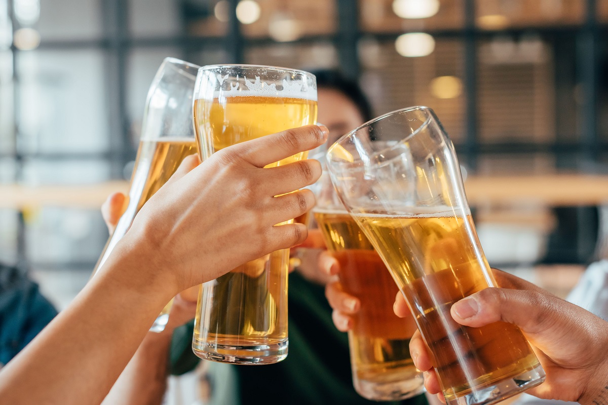 Close-up,Cropped,Image,Of,Friends,Clinking,With,Beer,In,Cafe