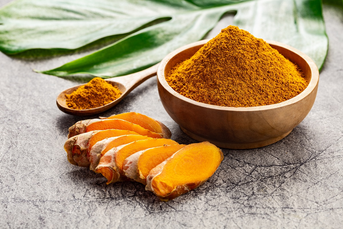 Turmeric,Powder,And,Fresh,Slices,Of,Turmeric,Root,On,Grey