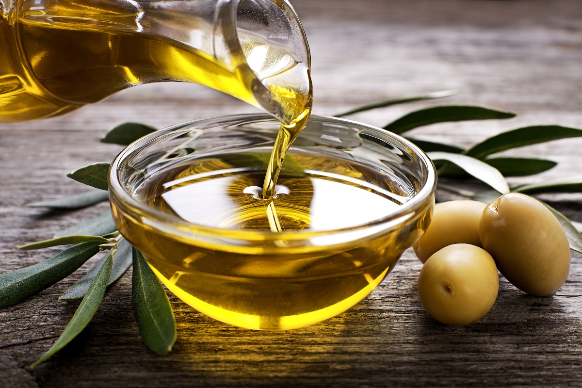 Bottle,Pouring,Virgin,Olive,Oil,In,A,Bowl,Close,Up