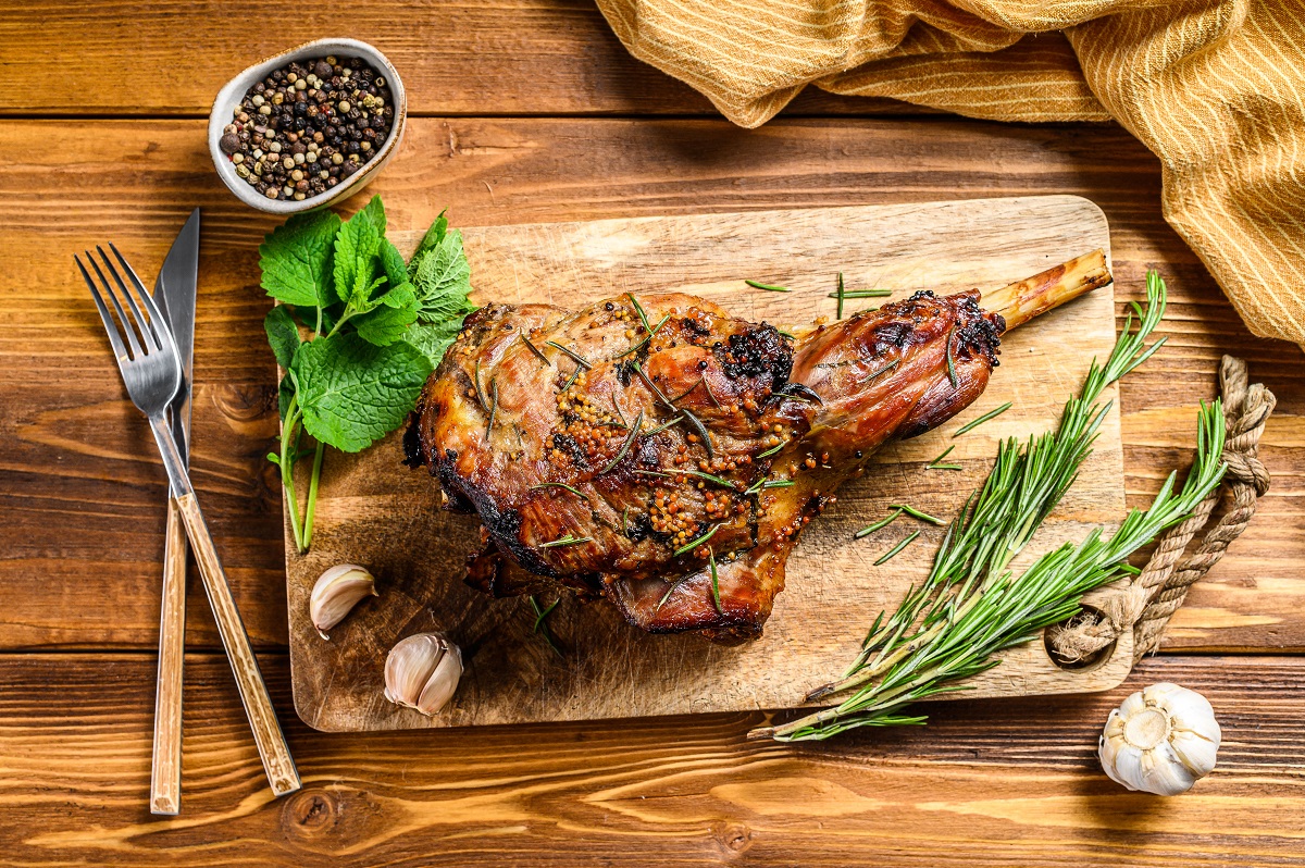 Roasted,Lamb,,Sheep,Leg,On,A,Cutting,Board,With,Rosemary.