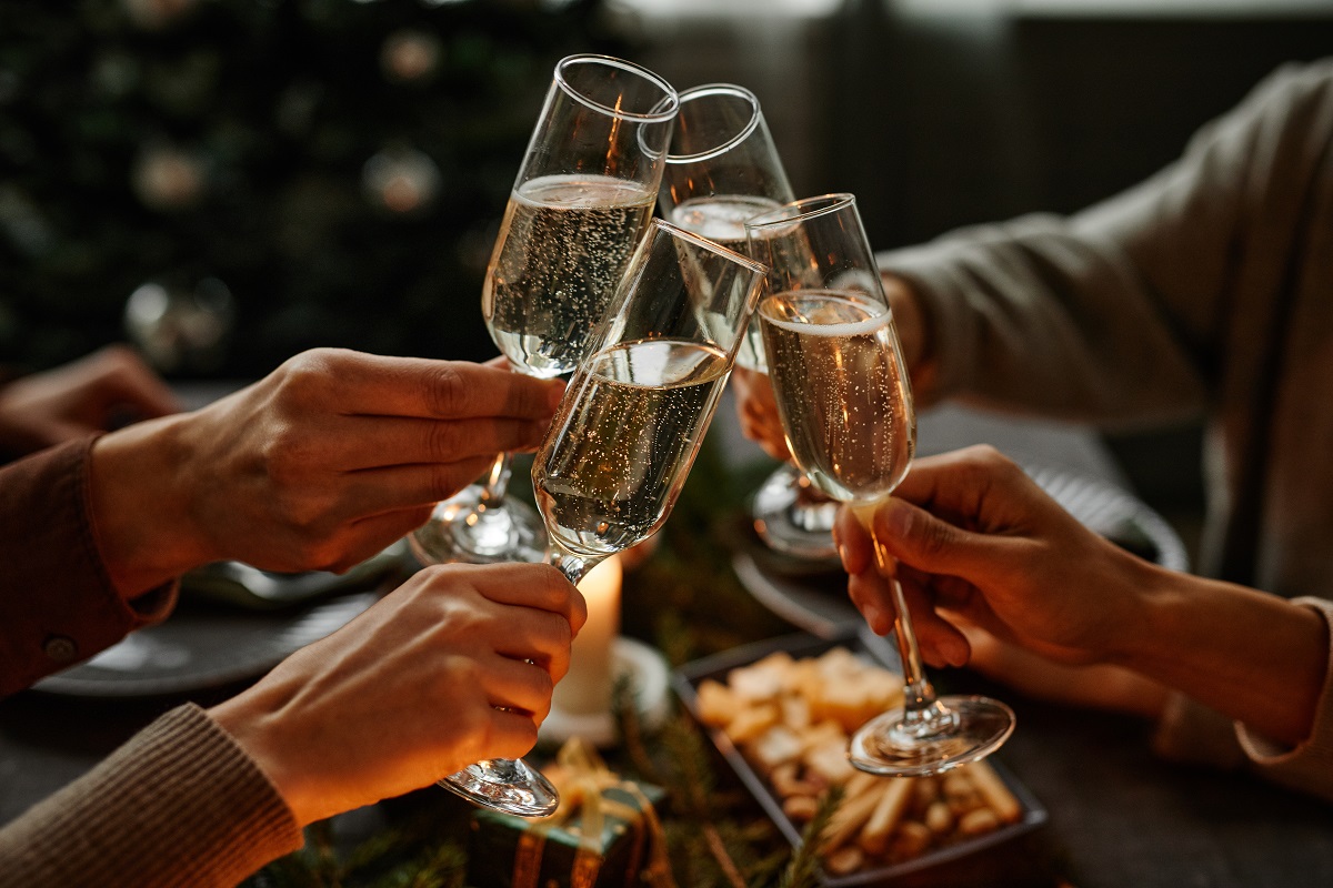 Close,Up,Of,Four,People,Enjoying,Christmas,Dinner,Together,And