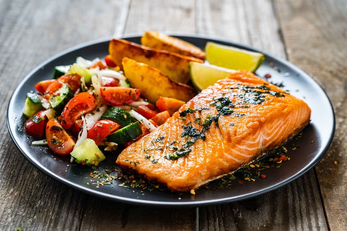 Fried,Salmon,Fillet,With,Fried,Potatoes,,Lime,And,Vegetable,Salad