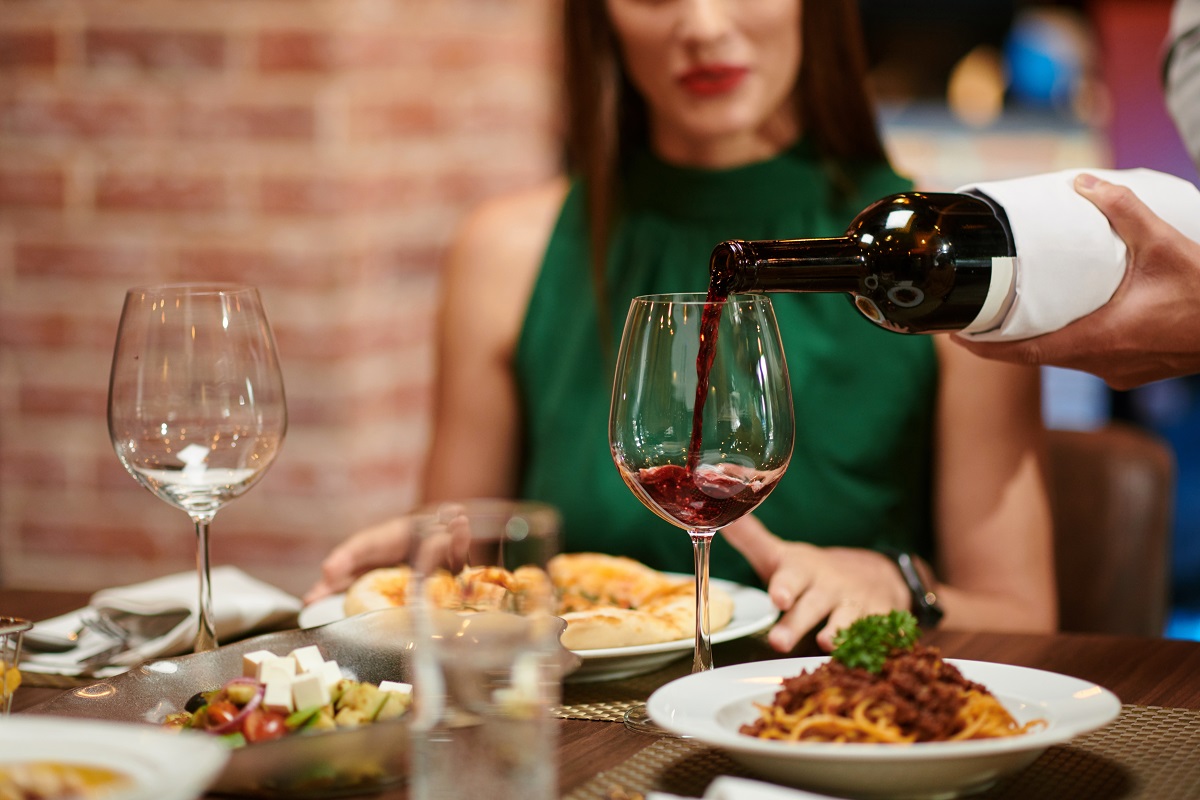 Waiter,Filling,Wine,Glass,For,Yuong,Elegant,Woman,Sitting,At
