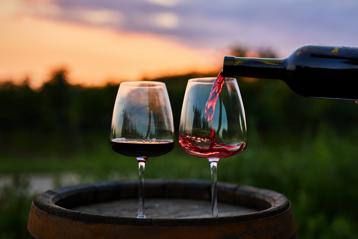 Pouring,Red,Wine,From,A,Bottle,Into,A,Glass,At